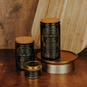 Side by side shot of the three sizes of Cozy Bakery soy candles – 15 oz jar, 11 oz jar, and 3.3 oz gold tin.