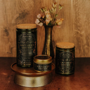 Side by side shot of the three sizes of Southern Gothic soy candles – 15 oz jar, 11 oz jar, and 3.3 oz gold tin.