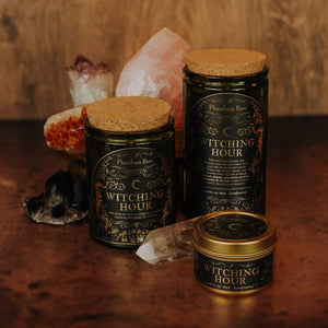 Side by side shot of the three sizes of Witching Hour soy candles – 15 oz jar, 11 oz jar, and 3.3 oz gold tin, with crystals in the background.
